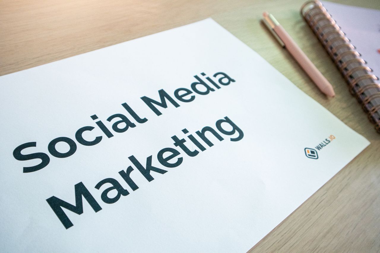 Vue rapprochée d’un document de marketing sur les réseaux sociaux posé sur un bureau, avec un stylo et un carnet.